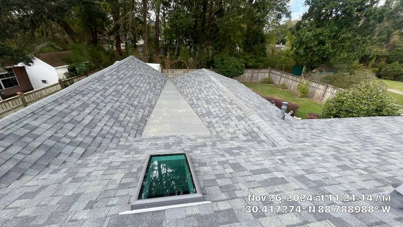 Gray shingle roof with a skylight, seen from the ridge